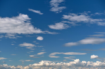 Bright landscape of white puffy cumulus clouds on blue clear sky