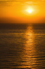 Bright beautiful sunrise at the calm sea. Solar disk over water. The sun's rays are reflected in the water. The Mediterranean Sea near Mersin, Turkey. Travel and tourism concept