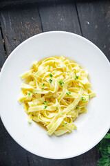 Fettuccine pasta or Tagliatelle creamy parmesan sauce healthy meal food diet snack on the table copy space food background rustic. top view