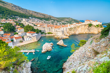 Old city Dubrovnik panorama. View of town roofs, cliff above the sea and small harbor with boats.