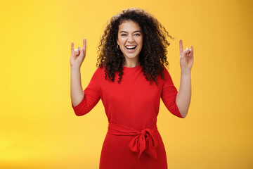 Rock n roll live. Charismatic excited young curly-haired woman in red dress feeling awesome as...