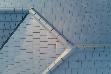 Closeup of house roof top covered with ceramic shingles. Tiled covering of building