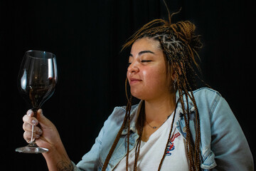 beautiful woman with braces drinks red wine in a glass