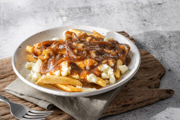 Delicious poutine with fresh cheese curd and gravy melted cheese into perfection on white background
