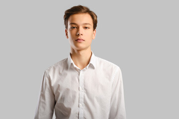 Portrait of handsome young man in white shirt over grey background