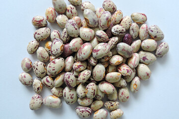 A pile of seeds of colorful dragon tongue beans, white background
