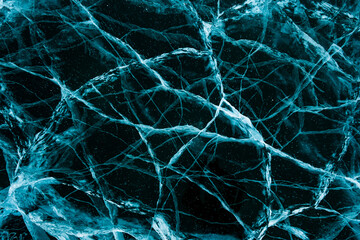 Texture of beautiful blue ice with cracks and air bubbles in the frozen lake. Winter nature background.