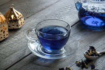 asian purple tea from clitoria flowers on a wooden table cup, teapot and dried flowers