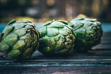 Fototapeta premium Several fresh artichokes, on the table. After picking from the vegetable garden