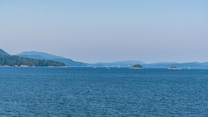 strait of Georgia between Vancouver and Victoria with small islands boats and blue sky