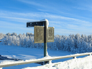 Markierung der Grenze zwischen Finnland und Schweden durch ein Schild auf der Brücke über den Fluss Etuväyla