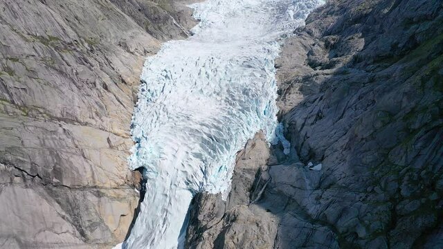 Flying away from a Glacier on top of a rocky mountain