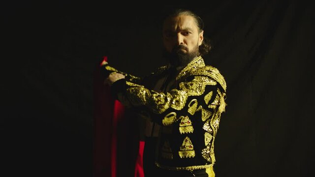 Male dancer or toreador imitating moves of matador bullfighter on black smoky background .  Man bullfighter dressed in bullfighting costume . Shot on ARRI Alexa cinema camera in Slow Motion 