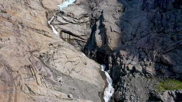 Glacier melting and forming a waterfall due to climate change and global warming