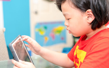 asian boy use tablet online learn from home