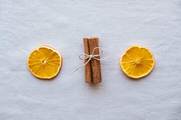 Holiday flat lay with natural decorations such as cinnamon sticks and dry orange slices on neutral...