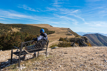 Tourist sitting on the bench and enjoying the view at the Battle Pass (Col de la Bataille) Vercors...