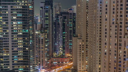 Fototapeta na wymiar Overview to JBR and Dubai Marina skyline with modern high rise skyscrapers waterfront living apartments aerial night timelapse