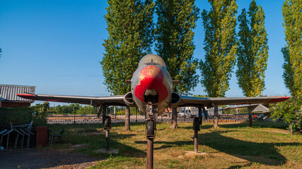 Training aircraft L-29. Supersonic jet aircraft for practicing mastery in flight. Installed in the Victory Park in Nizhny Novgorod. Against the backdrop of blue sky and green trees.