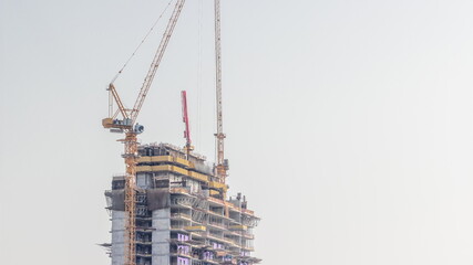 Skyscraper under construction with cranes and iron frame timelapse