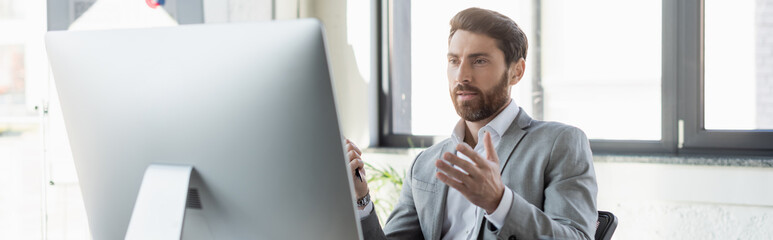 Businessman having video chat on computer in office, banner.