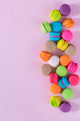 Cake macaron or macaroon on turquoise pastel background from above. Colorful almond cookies on dessert top view.