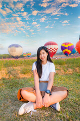 A young woman who visits the cosmos flower field and looks for a hot air balloon festival in Chiang Rai province of Thailand