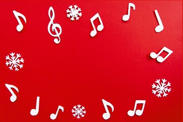 frame of notes and christmas decorations on red background. Christmas music concept