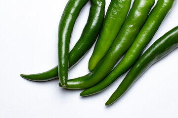 A bunch of large green hot peppers as a frame on white, top view, place for text.