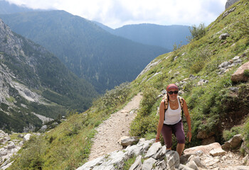 Naklejka na ściany i meble young cute woman hiker on a rugged high mountain trail