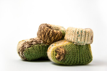 Crochet green baby booties, on a white background, handmade baby booties, warm baby feet is a guarantee of health. space for text