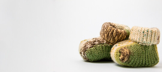 Crochet green baby booties, on a white background, handmade baby booties, warm baby feet is a guarantee of health. space for text