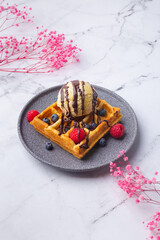 Belgian waffles with ice cream berries and flower on green
