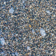 sea beach of small multi-colored pebbles as a natural background