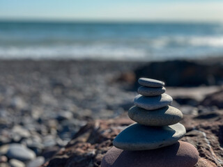 Stones piled up by size on lonely beach copy space