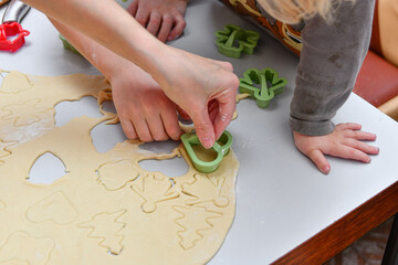 Children make different shapes from rolled dough for baking in the oven.
