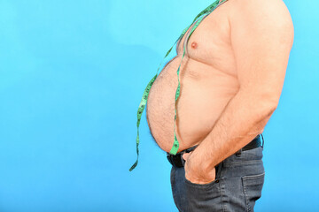 A fat and fat man with a big belly holds a centimeter around his neck to measure his waist.