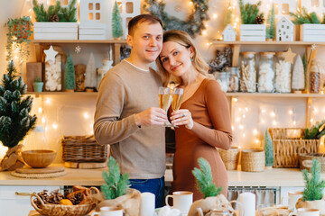 a couple in love with glasses of champagne in the christmas's kitchen. romantic.