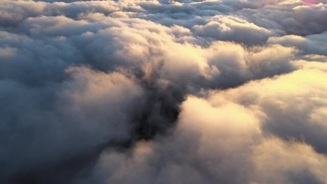 Aerial view from high altitude of distant city covered with puffy cumulus clouds forming before rainstorm in evening. Airplane point of view of cloudy landscape
