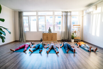 Group resting near window during yoga session