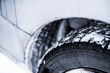 Closeup view of winter tires on a road covered with snow in cold freeze winter months.