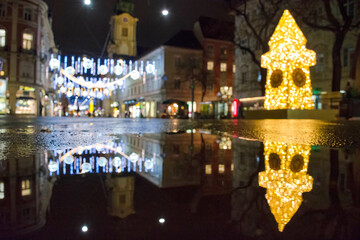Blurred Christmas lights with famous Clock Tower on Herrengasse street, at night, in the city...