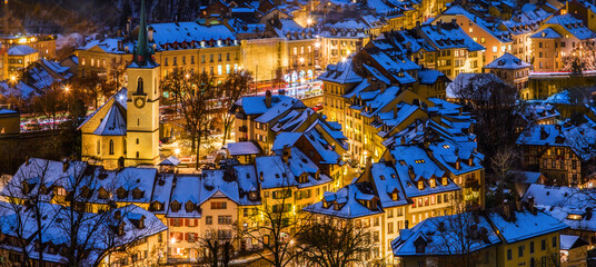 Alleys and lanes of the town center of Bern in winter blue hour with snow-covered roofs and illuminated buildings in Christmas season, Rosengarten, Bern, UNESCO, Switzerland