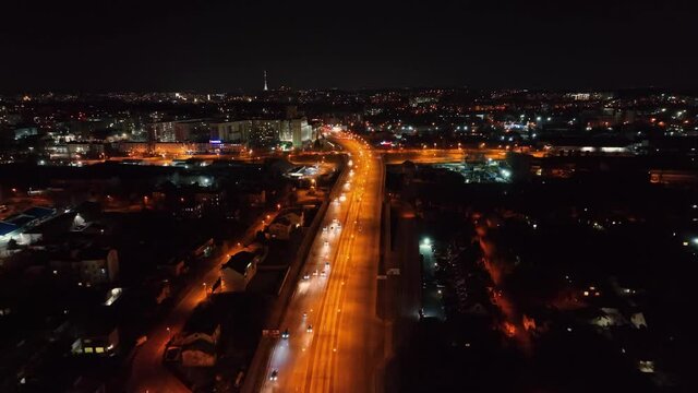 Aerial view Traffic at night on the highway connecting major cities. View of the city glowing at night from a height. Nightlife in the big city.