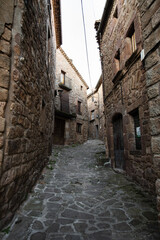 Fototapeta na wymiar Old narrow medieval street in Catalonian village L'Estany, Spain