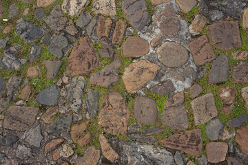 texture of assorted brown stones and ashes surrounded by grass and cement