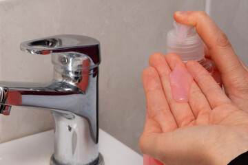 Close up of female girl poring soap to wash hands