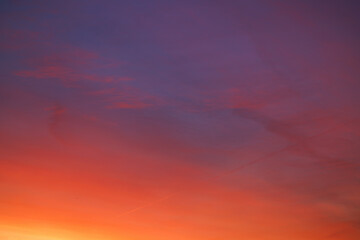 The sunrise is dramatic. The sky is the color of fiery red-orange, the silhouette of a flying plane on the horizon.