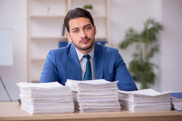 Young male employee unhappy with excessive work in the office