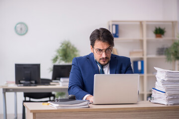 Young male employee unhappy with excessive work in the office